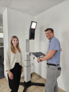 Michaela Simon-Mathes zeigt Bürgermeister Alexander Knahn den neuen digitalen Fotoautomaten.