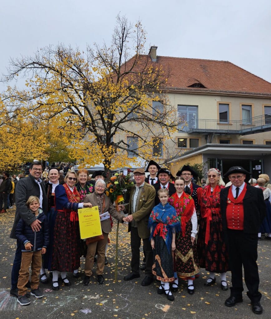 Bürgermeister Alexander Knahn gratuliert zusammen mit Mitgliedern des Heimat- und Trachtenvereins dem Gewinnerpaar des diesjährigen Hammeltanzes.
